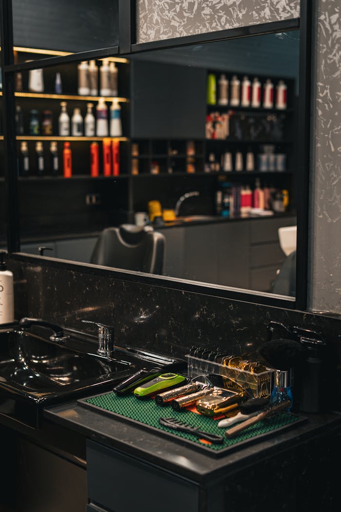 A sleek barbershop interior showcasing hair styling tools and products on the counter.